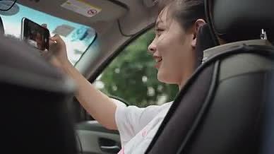 时尚靓丽的女士在车内使用新款智能手机自拍视频的预览图